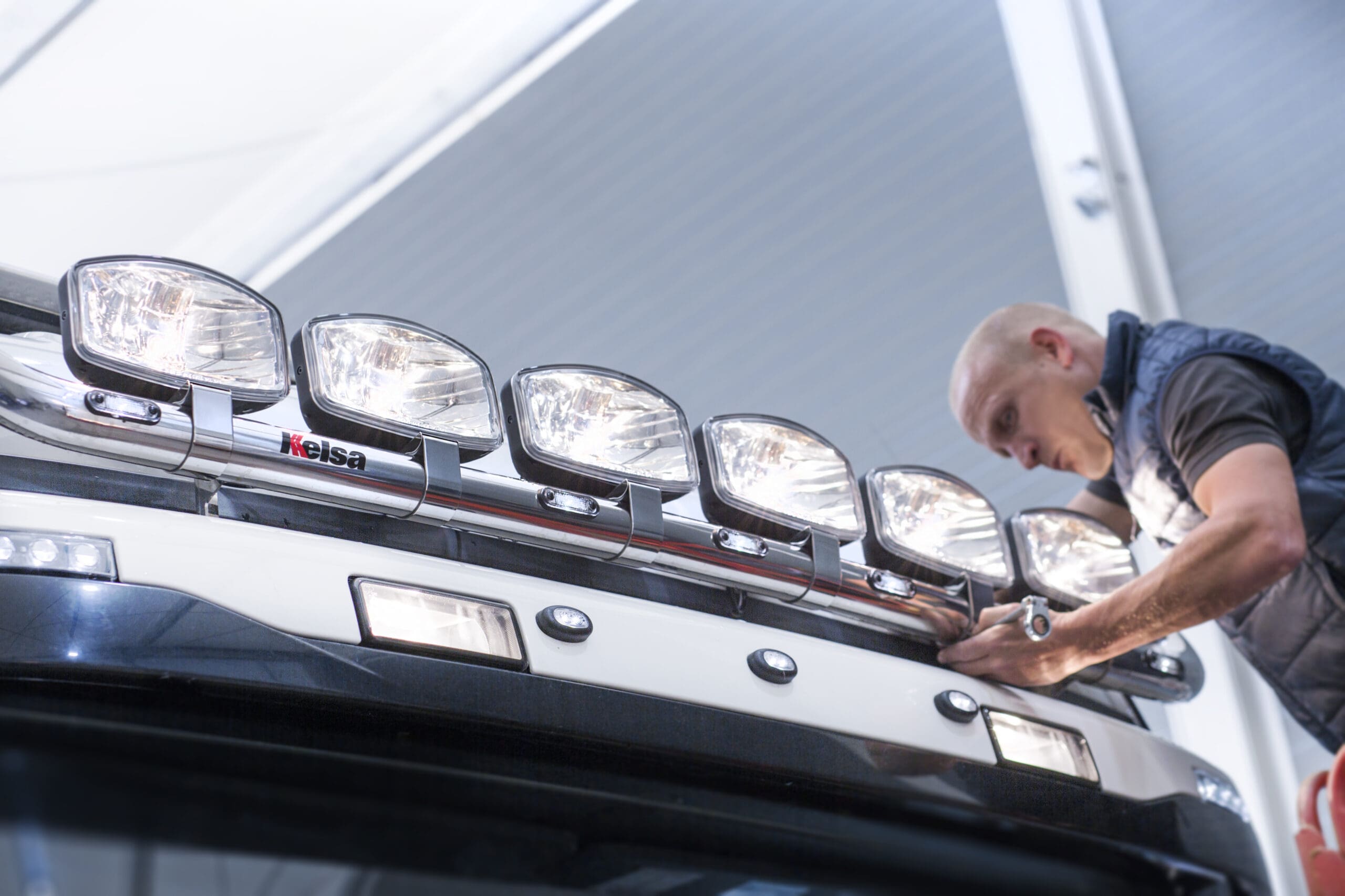 Engineer fitting the lights to the top of a Scania truck.
